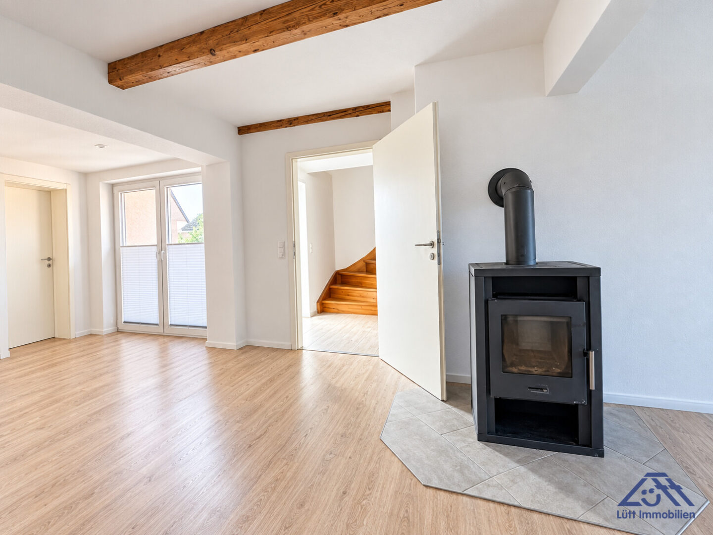 Wohnzimmer mit Ofen - Lütt Immobilien Malente